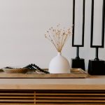 white ceramic vase near two black table decors