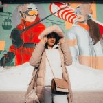 a person standing in front of a wall with art