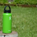 green Hydro Flask tumbler on wood slab