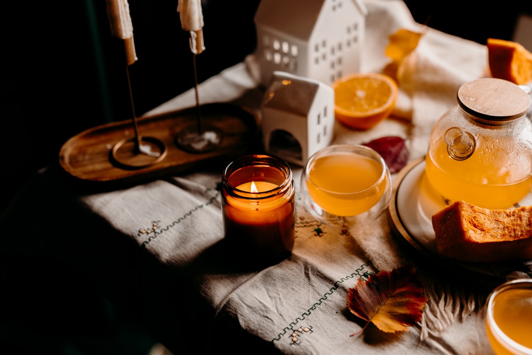 Cozy autumn table setting with lit candle and orange slices