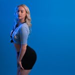 a woman posing for a picture with a blue background