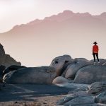 a person standing on top of a large rock