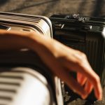 a hand is reaching for a piece of luggage