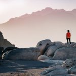 a person standing on top of a large rock