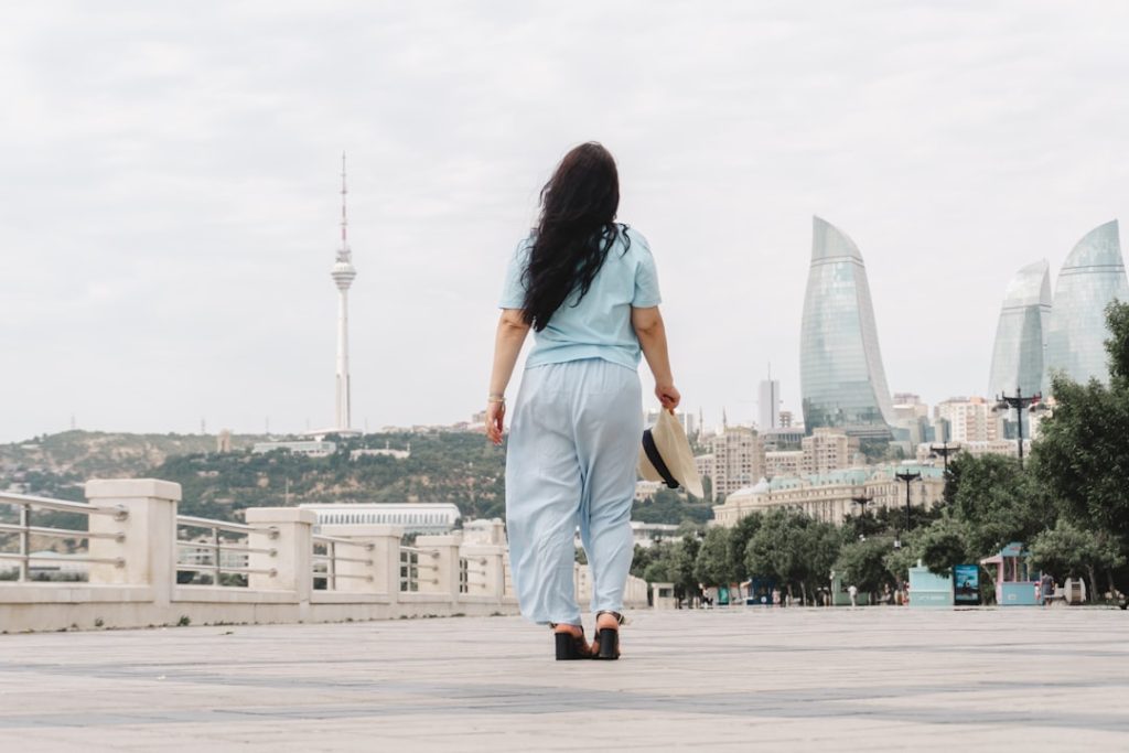 A woman walks towards a city skyline with modern buildings