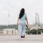 A woman walks towards a city skyline with modern buildings