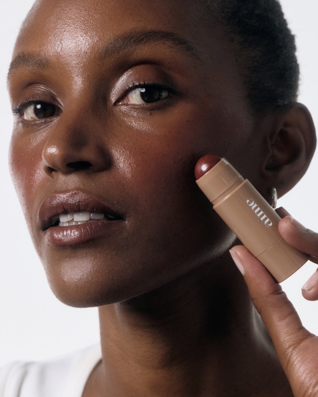 Aime skincare products arranged in a soft blush beauty editorial