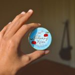 person holding blue and white round container