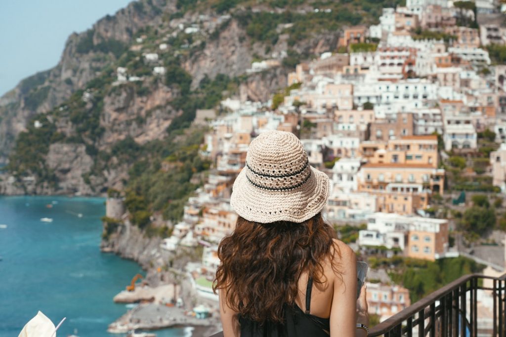 A woman standing on a balcony looking at the ocean