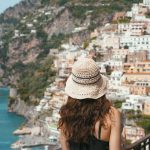 A woman standing on a balcony looking at the ocean